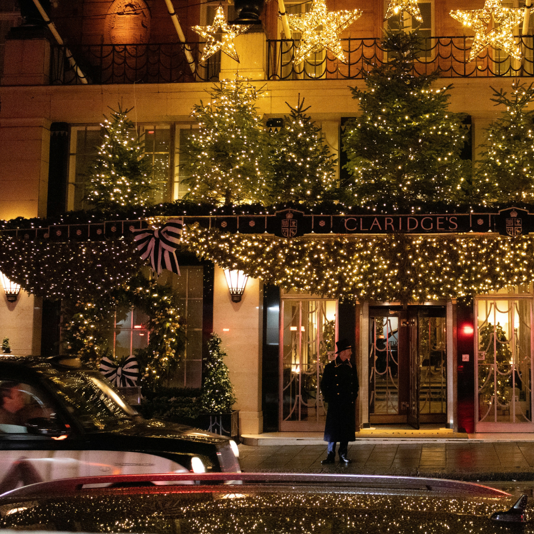 Hotel entrance decorated with Christmas trees and festive lights at night